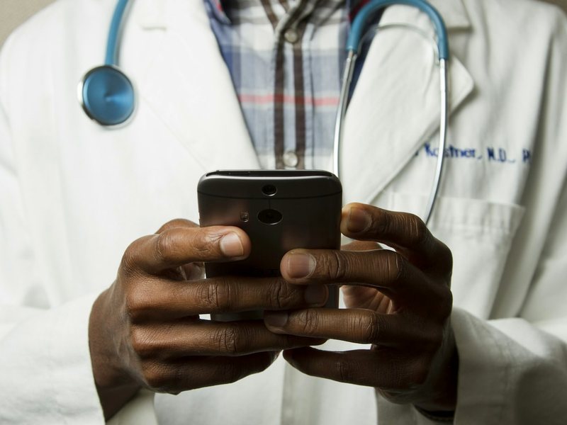 A person holding a phone upright, standing in for a recorded verification